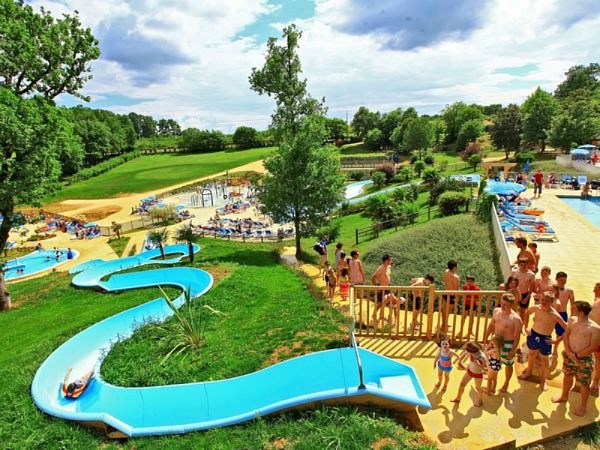 Gezinscamping in de Dordogne met tenten tussen de bomen en kinderen die buiten spelen